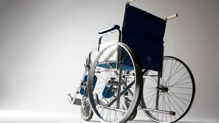 A modern heavy duty wheelchair sits outdoors on a clean paved patio.