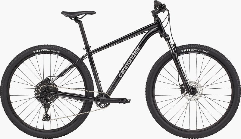 A cyclist's hand using the gear shifter on a mountain bike handlebar.